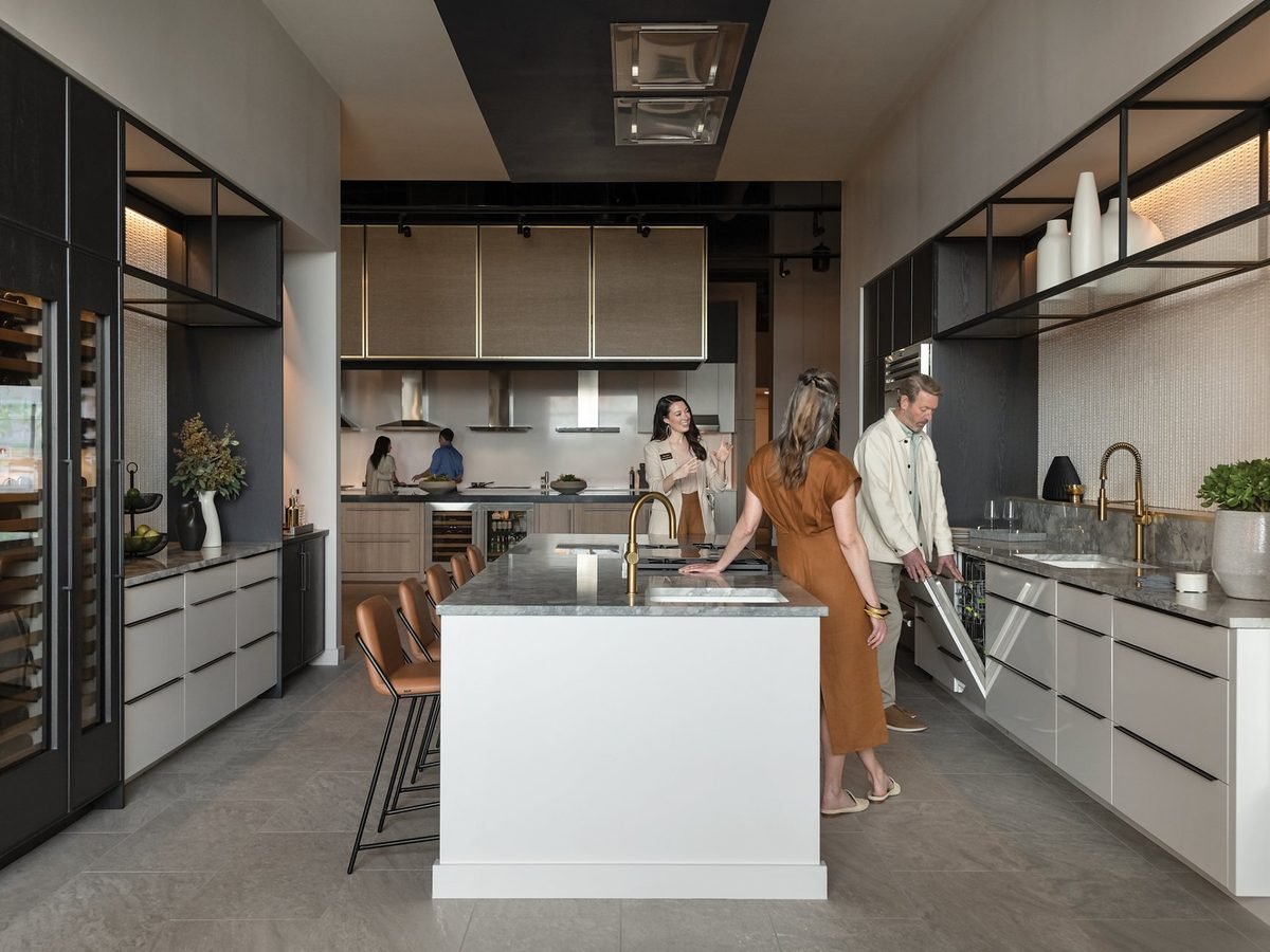 Homeowners reviewing newly installed built-in appliances in a modern kitchen