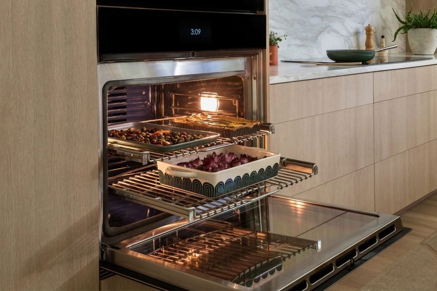 Built-in wall oven with the door open and food on multiple racks