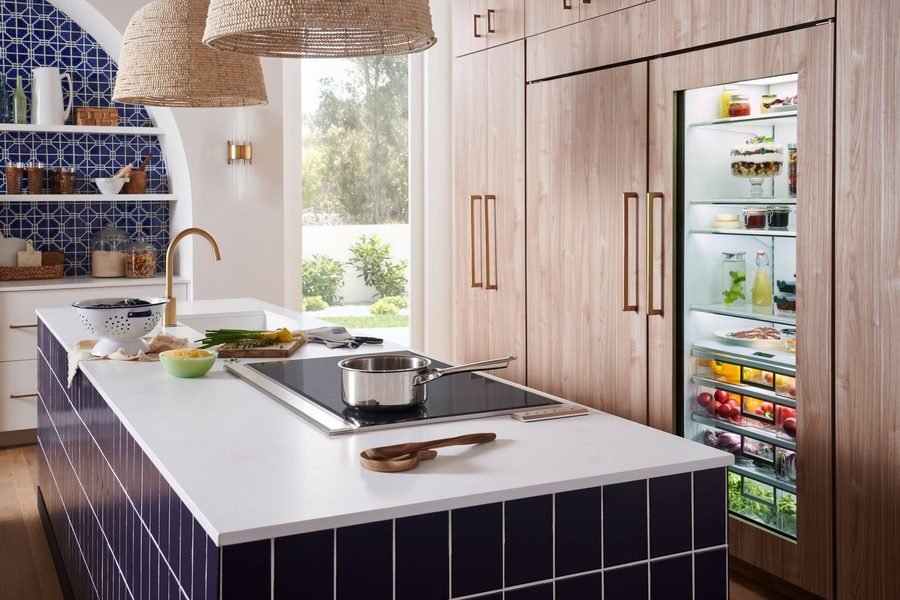 Built-in refrigerator with the glass door open, fully stocked